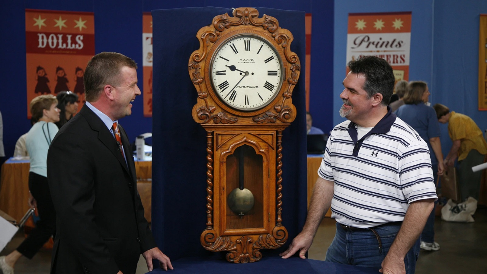 Sean Delaney (right) appraises an English Victorian wall clock, ca. 1870, in Dallas, Texas.
