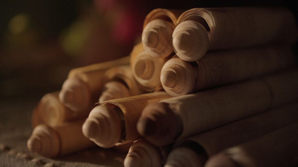 A stack of paper scrolls on wooden dowels