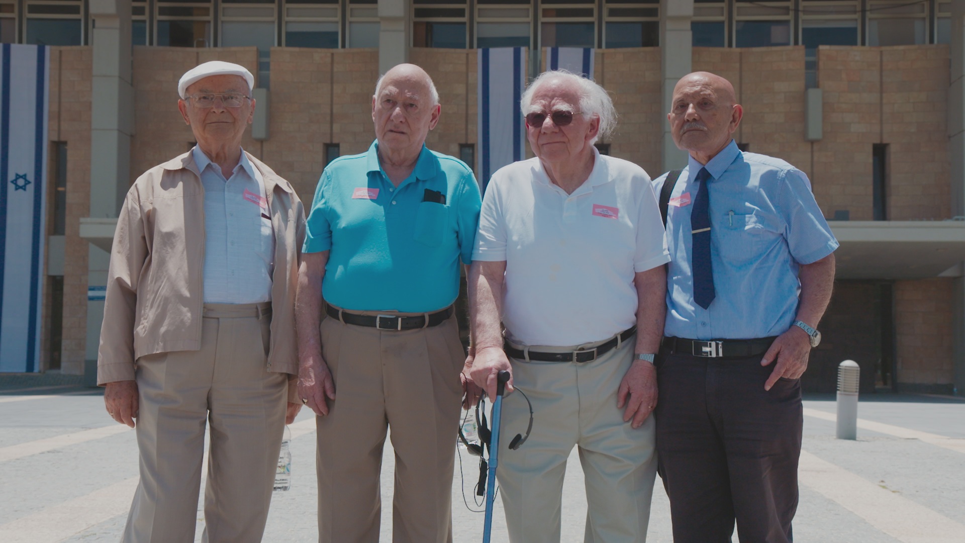 Four older men standing together