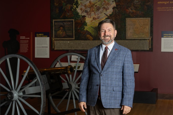 Scott Alvey posing in front historical museum exhibits