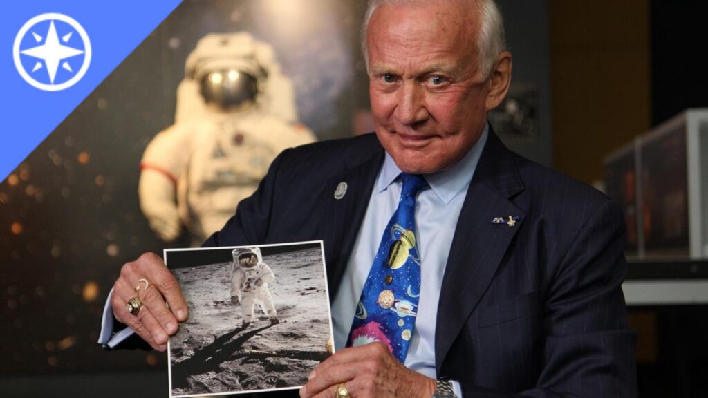 A man holding up a photo of an astronaut on the moon,