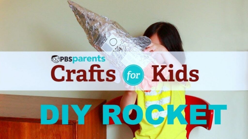 A kid holding up a DIY rocket covered in tin foil
