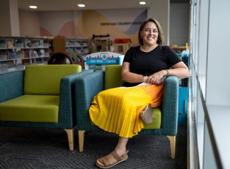 Paige Halpin Smith seated and smiling in a chair in a library.