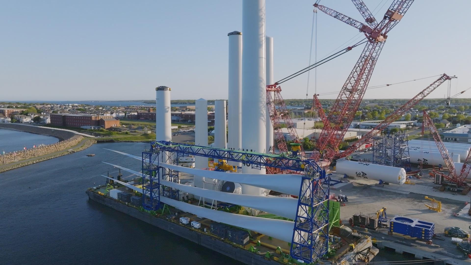 Huge wind turbine blades stacked at a shipyard