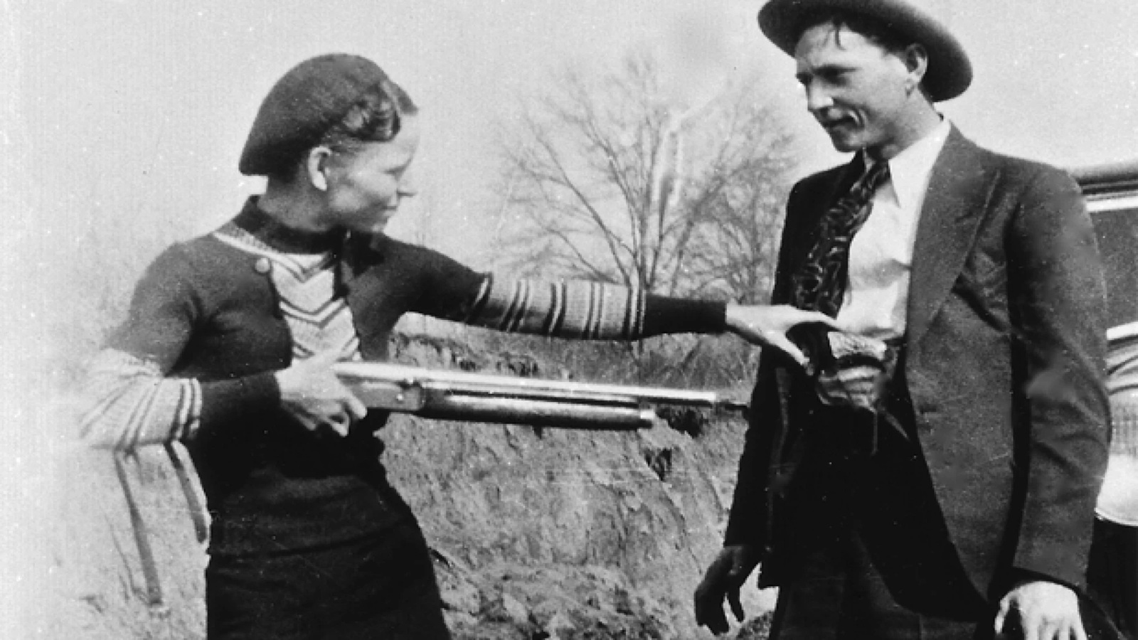 Black and white photo of Bonnie pretending to hold Clyde at gunpoint