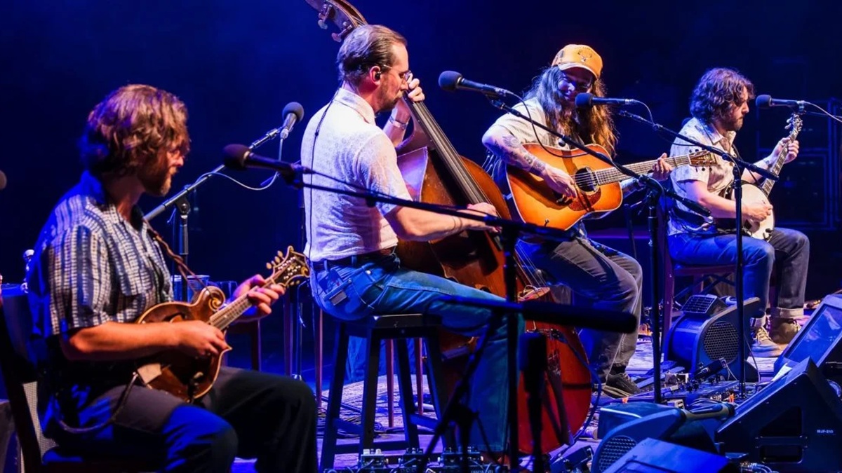 billy strings on guitar with other musicians on stage