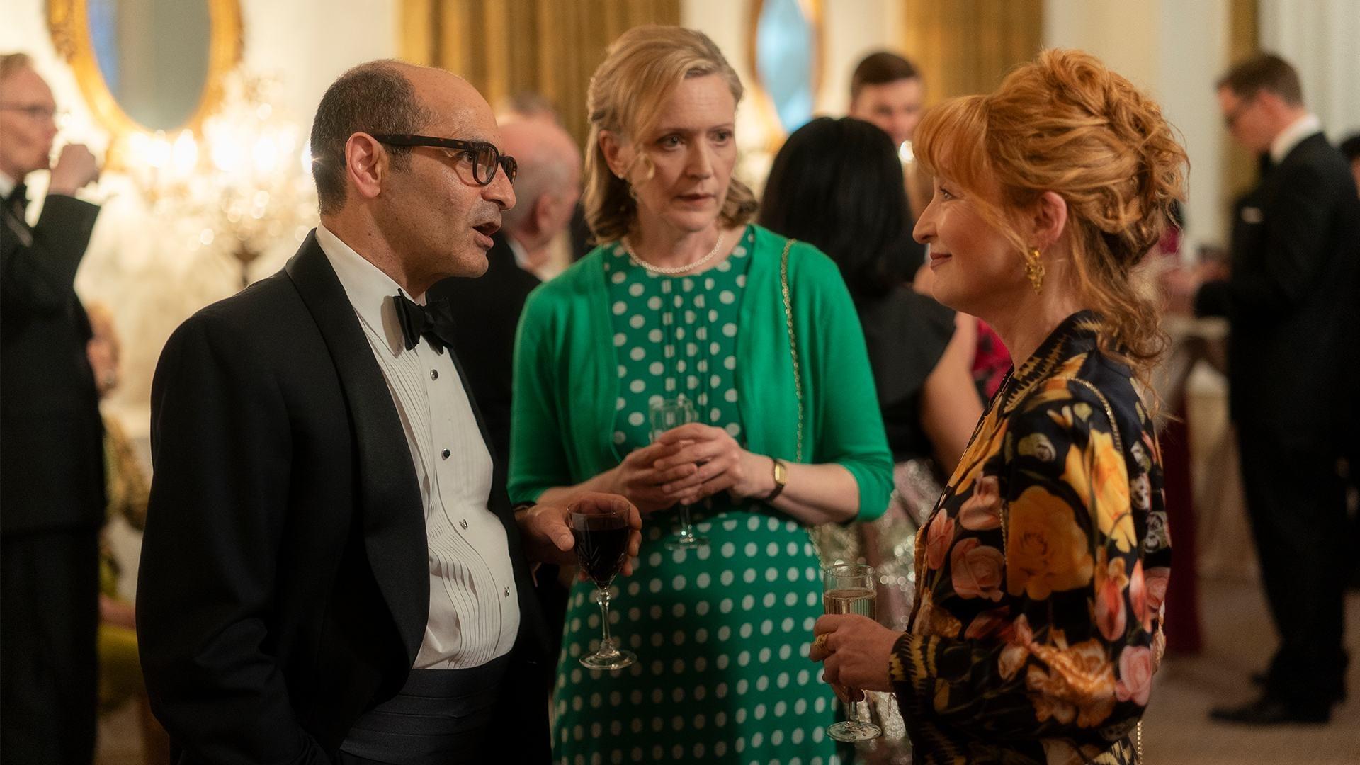 Susan speaking with a couple at a cocktail party