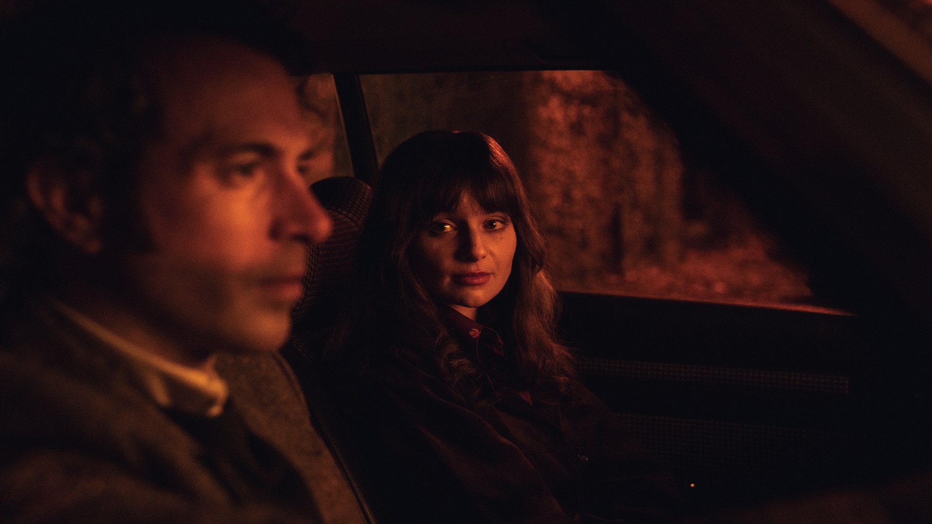 Dimly lit Michael and Cushia in a car at night
