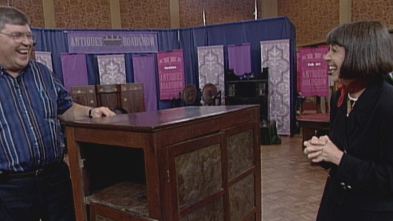 Guest and appraiser stand next to cabinet