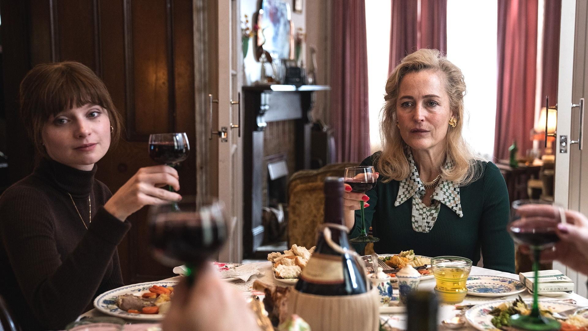 Cushla and another woman holding wine glasses at a dining table