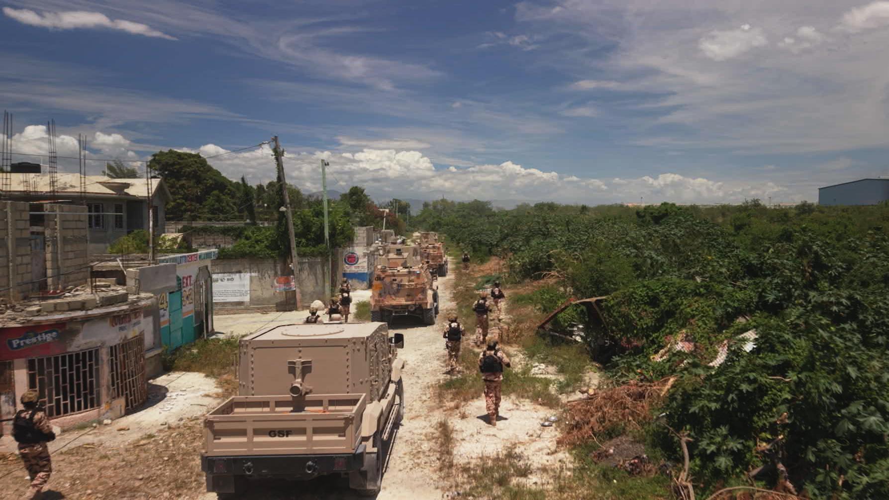 military vehicles and soldiers along street in haiti