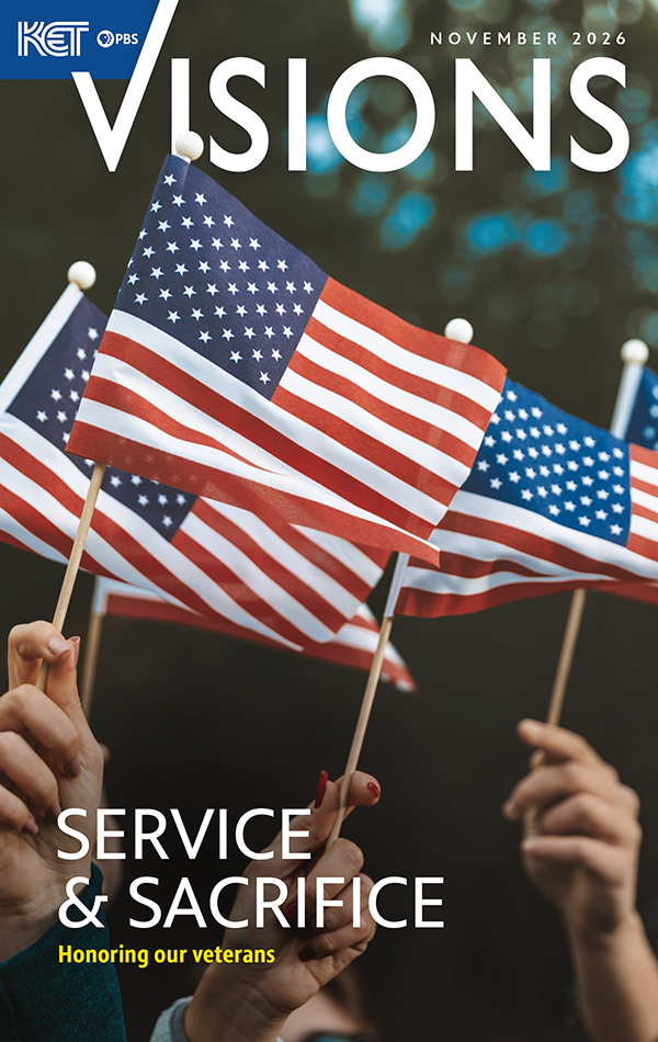 The cover image for November 2026 edition of Visions magazine showing people's hands waving small US flags.